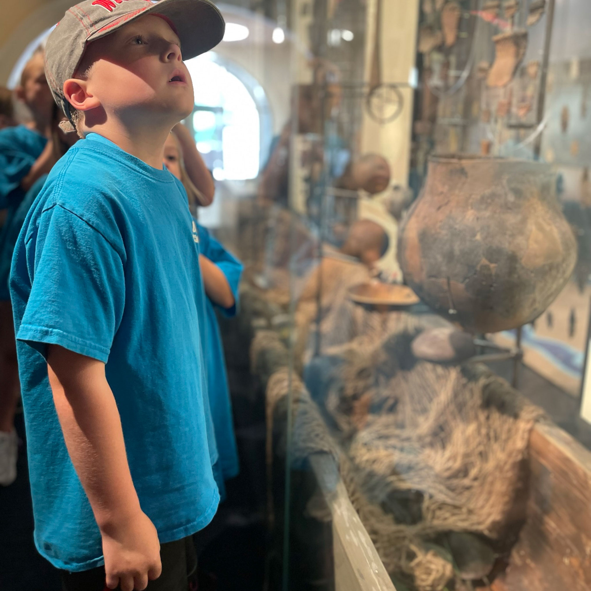 Child inspecting artifacts in People of the Waters